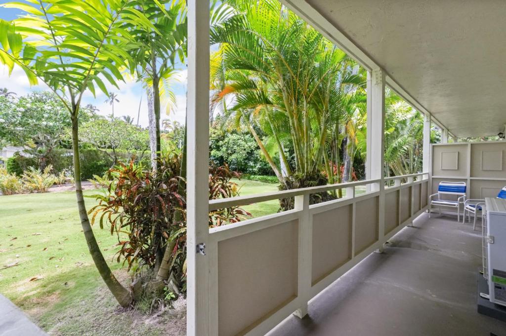 a porch with a view of a yard with palm trees at Kahaki Hale in Kapaa