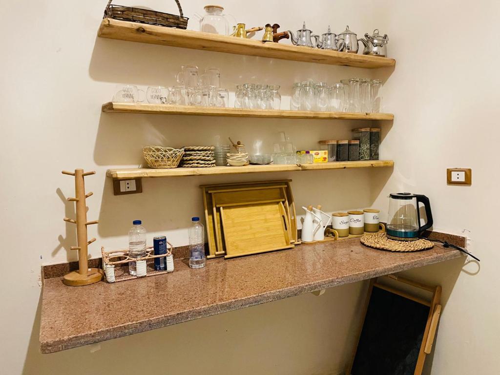 a counter in a room with glasses on shelves at Shali Home in Siwa