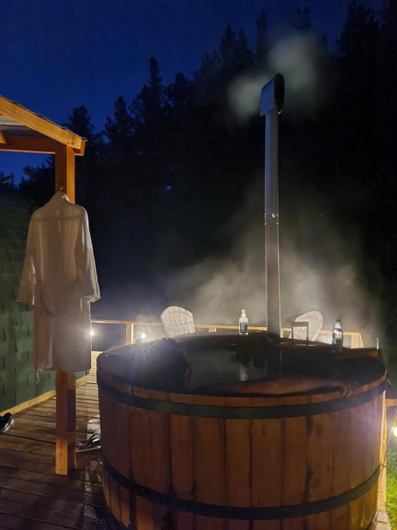 a hot tub in a barrel on a deck at night at Espacio Verde in Juan Chico