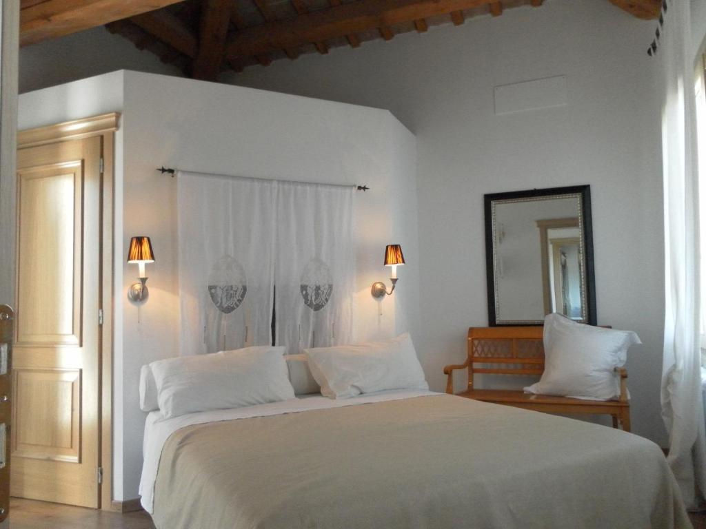 Un dormitorio con una cama blanca y un espejo. en Villa Riviera Naviglio Venezia, en Vigonovo