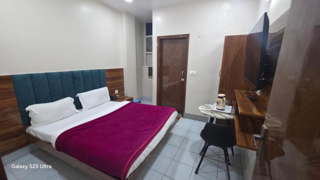 a bedroom with a bed with a purple blanket at fab THE MALEEN New Delhi in New Delhi