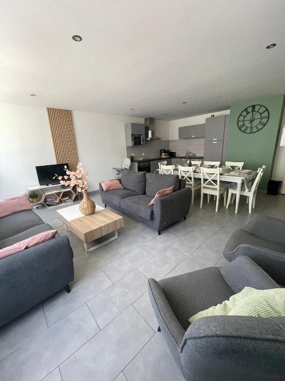 a living room with couches and a table and a kitchen at Maison Lac de Chalain - Jura in Fontenu