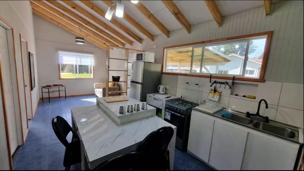 a kitchen with a sink and a table with chairs at Huella de Luna in Valdivia