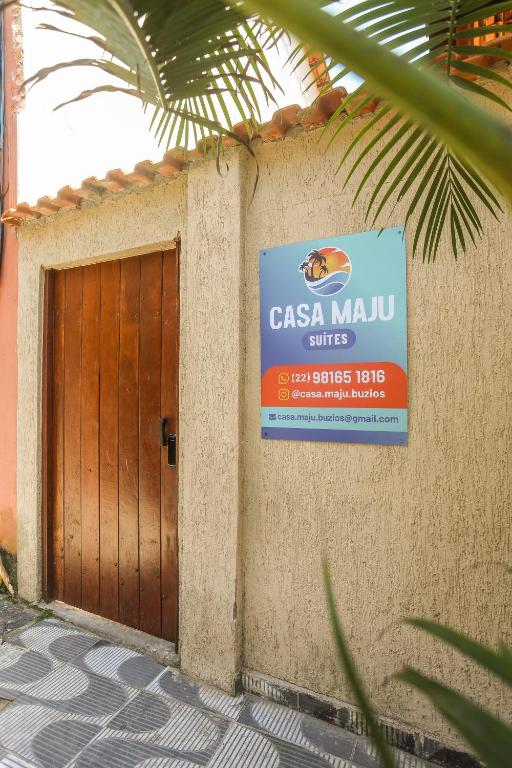 a sign on the side of a building with a door at Casa Maju Suites in Búzios