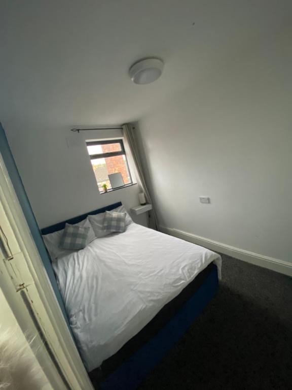 un piccolo letto in una piccola stanza con finestra di Blissfull dreams 1 bedroom apartment a Hull