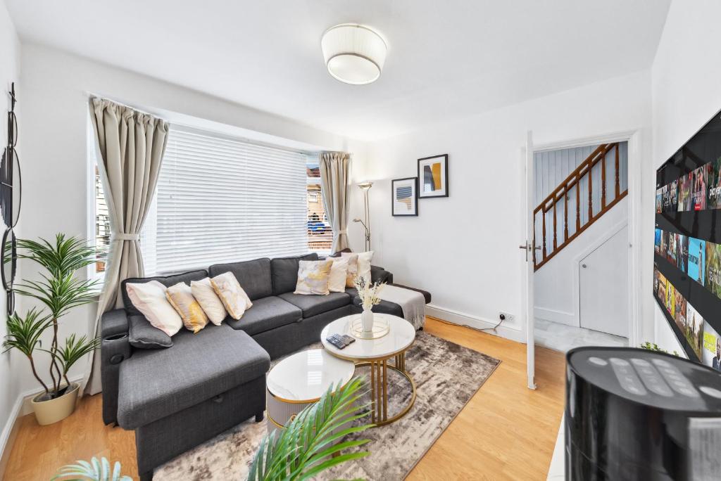 a living room with a couch and a table at Quincy's Homes in Dartford