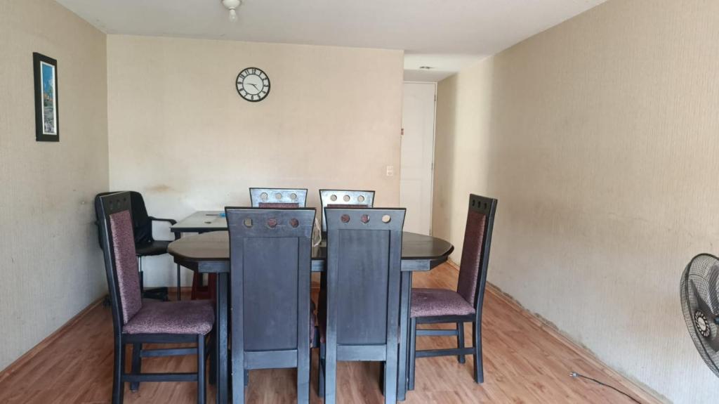 une table à manger avec des chaises et une horloge murale dans l'établissement Judith Milka, à Chiclayo