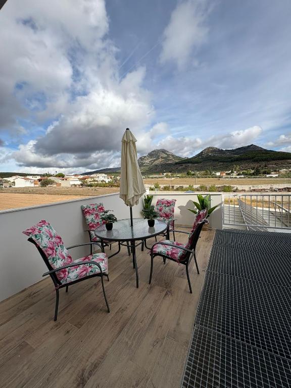 a patio with a table and two chairs and an umbrella at Alojamientos, BALCÓN A LA SIERRA AHILLOS in Alcaudete