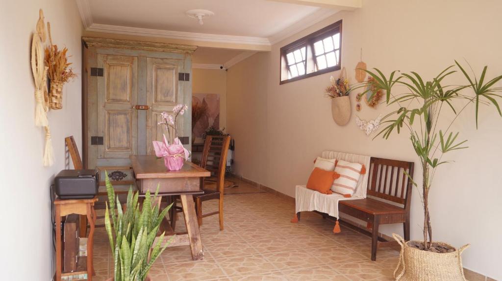 a living room with chairs and a table and a window at Recanto das Libélulas Pousada in Tiradentes
