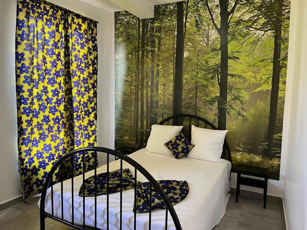 a bedroom with a bed and two large windows at une chambre dépaysante in Tarrafal