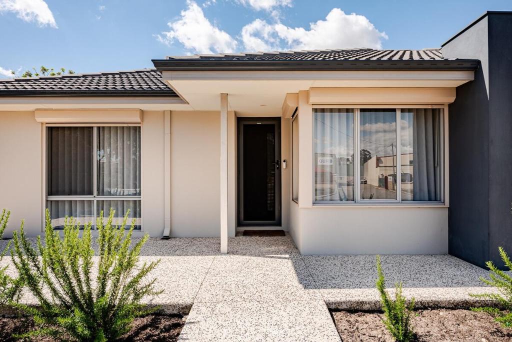 a white house with a black door at Modern Bassendean Abode in Perth