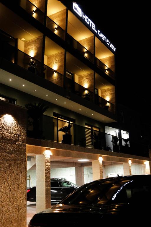 a car parked in front of a building at night at Hotel Castle View in Krujë