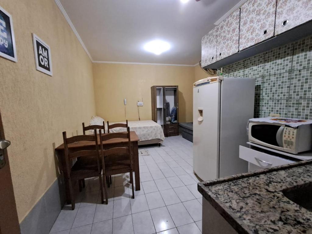 プライア・グランデにあるFlórida Houseのキッチン(冷蔵庫、テーブル、椅子付)