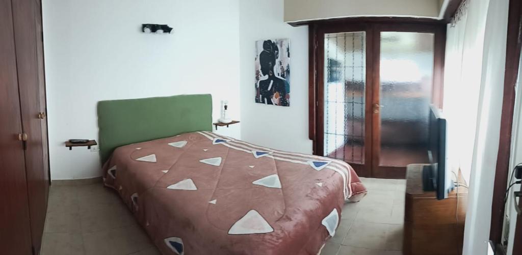 a bedroom with a bed with a brown and white comforter at La perla del mar in Mar del Plata