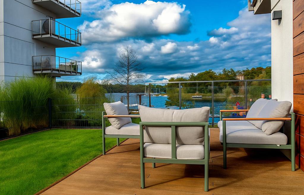 eine Terrasse mit 2 Stühlen und Blick auf das Wasser in der Unterkunft Marina Waterfront - najlepszy widok na Jeziorak in Iława