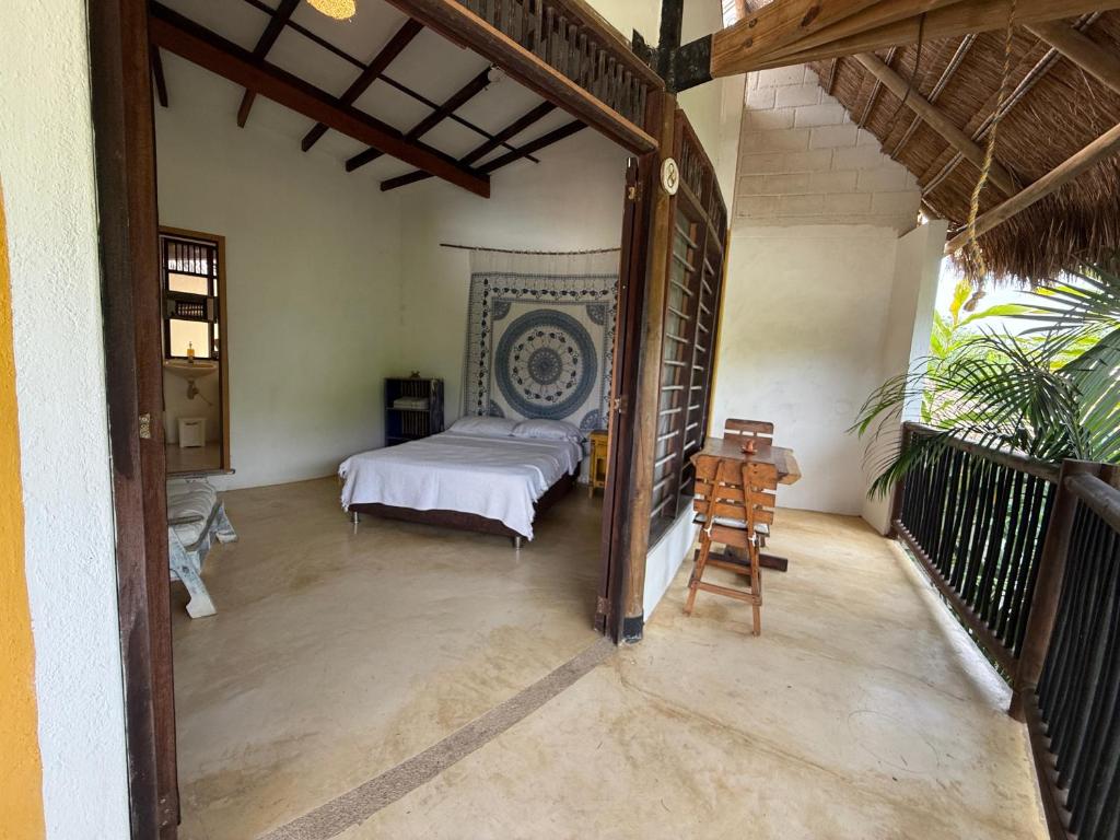 a bedroom with a bed and a table in a room at Hostal El Bohío in Palomino