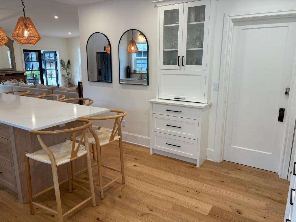 a kitchen with a white counter and chairs and a table at Charming Victoria Character Home-Pet Friendly in Victoria