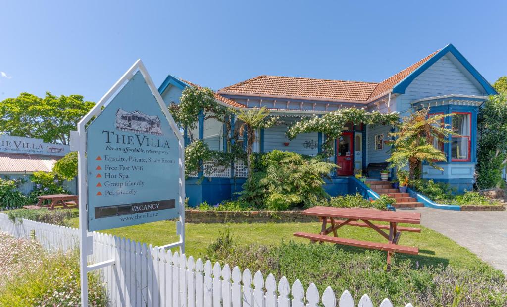 Un cartel delante de una casa con una mesa de picnic. en The Villa, en Picton