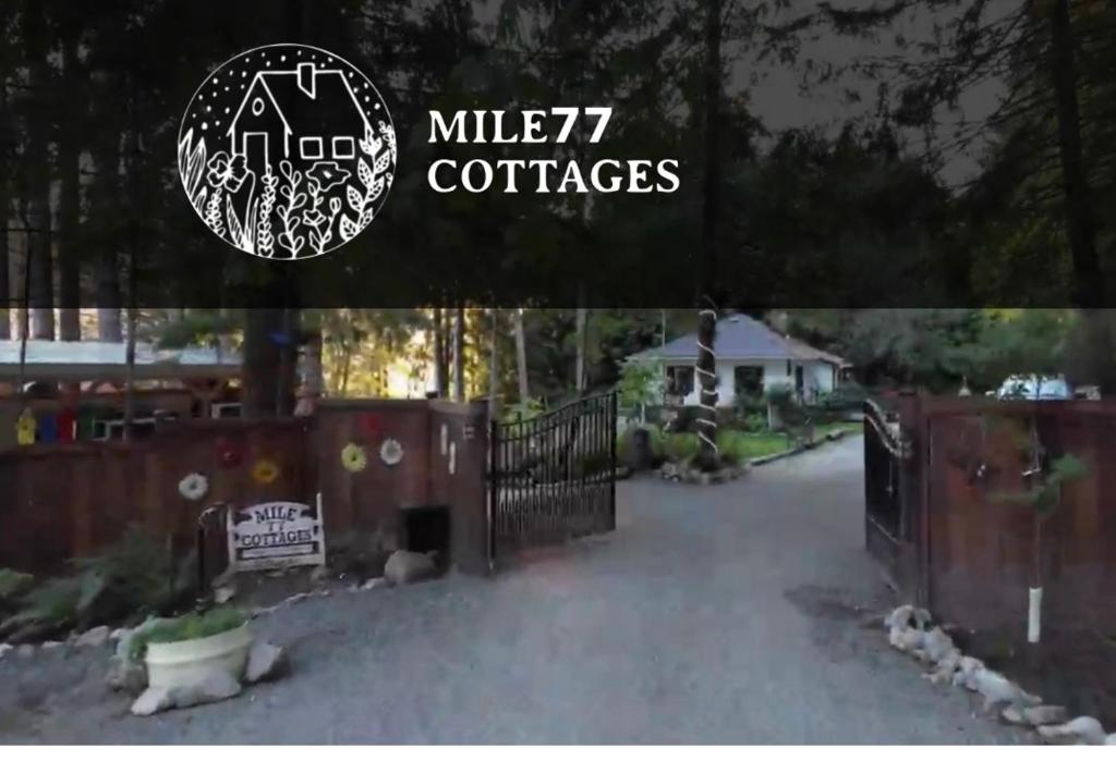 ein Bild einer Auffahrt mit einem Tor und einem Haus in der Unterkunft Mile 77 Cottages Lakefront 100yr old Railway Cottage in Youbou