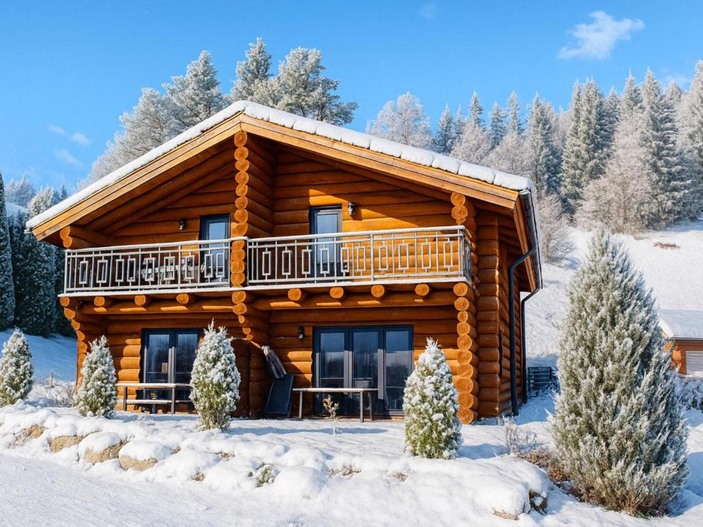 a log cabin in the snow with a balcony at Jenig 1A in Jenig