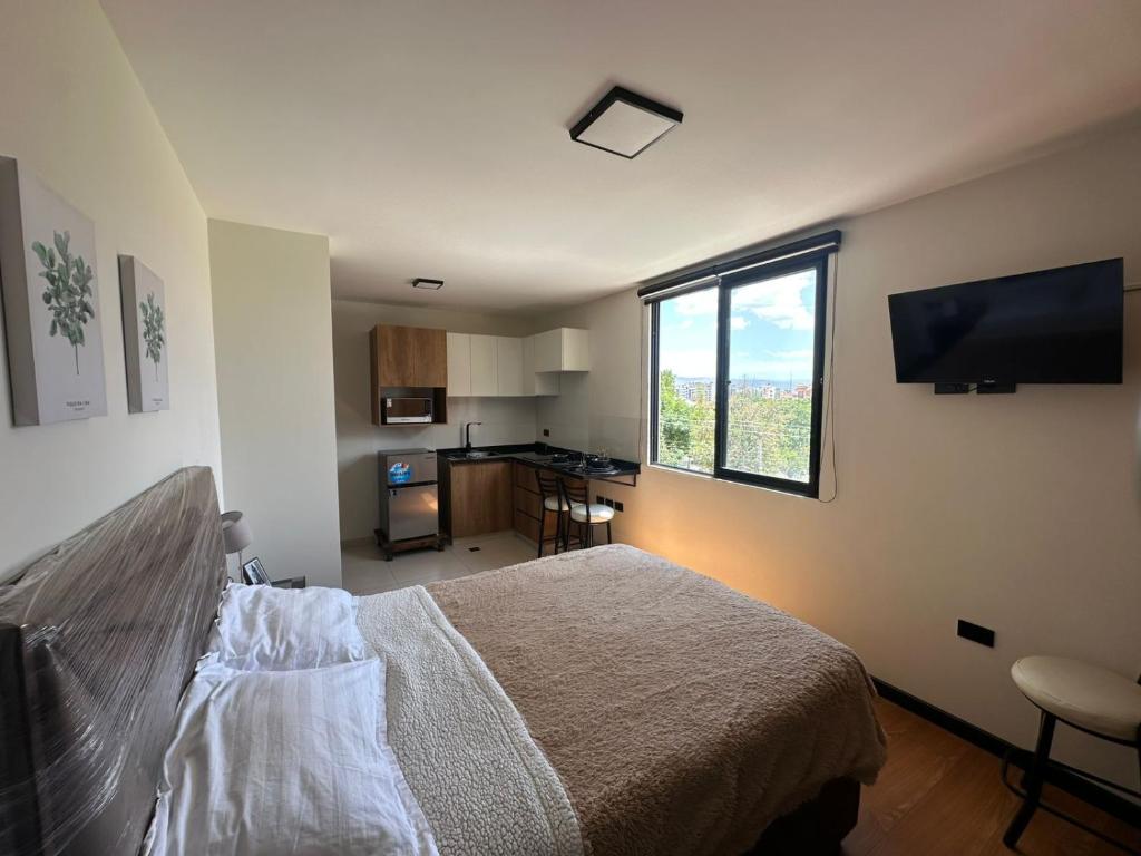 um quarto com uma cama e uma janela grande em Monoambiente moderno y ubicación ideal em Cochabamba