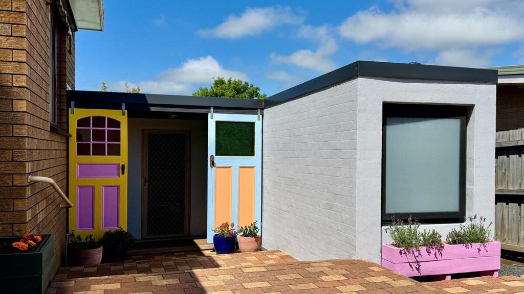 a brightly colored shed with a colorful door at Koala Cottage in Leongatha