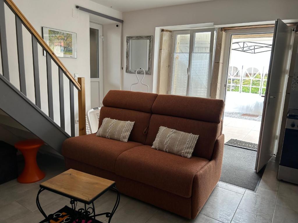 a living room with a couch and a table at Charmant gîte avec terrasse près du Lac de Madine, idéal pour 2 à 4 personnes - FR-1-585-90 in Buxières-sous-les-Côtes