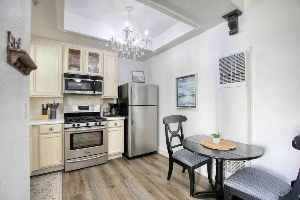 een keuken met een tafel en een roestvrijstalen koelkast bij Harborlight Manor in Oceano