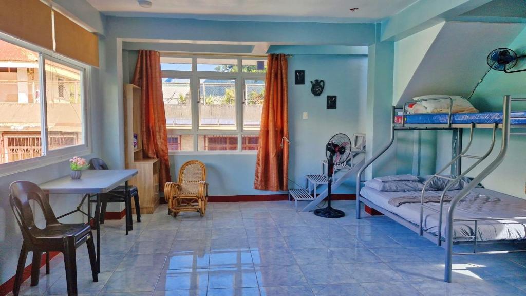 ein Schlafzimmer mit einem Etagenbett, einem Tisch und einem Schreibtisch in der Unterkunft Peaks&Pedals Transient in Irosin