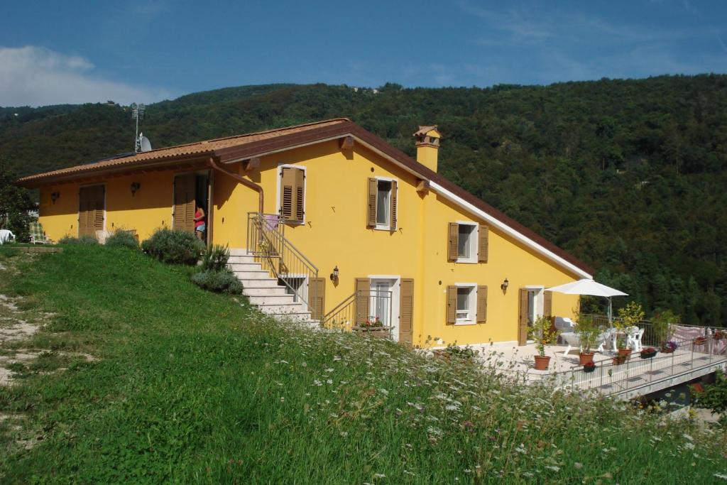 ein gelbes Haus an der Seite eines Hügels in der Unterkunft Agape in Caprino Veronese