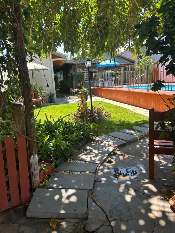 a park with a bench next to a yard at Pousada e Hotel Italian Garden House in Campo Grande