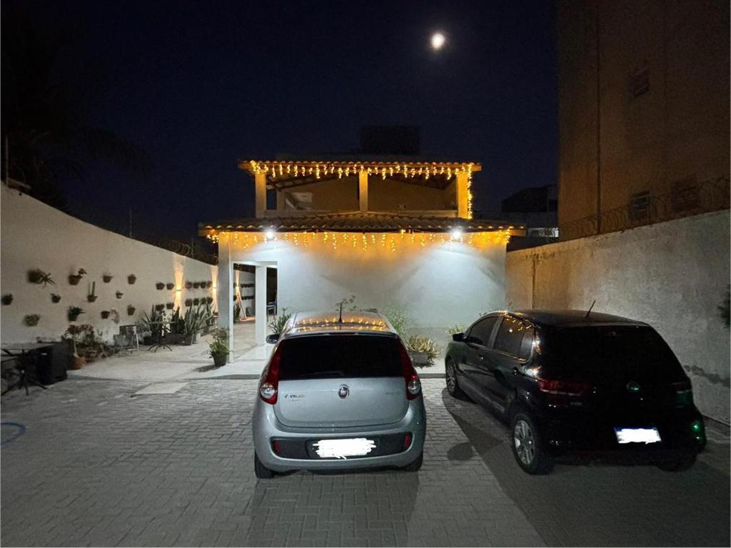 two cars parked in front of a building at night at Pousada Flor do Sol in Fortaleza