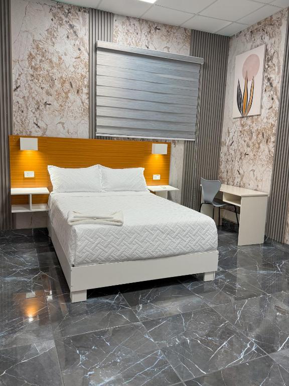 a bedroom with a bed and a desk at Hotel baramar moca in Moca