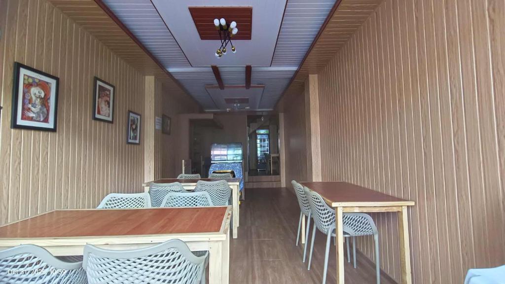 a restaurant with white chairs and a table and a counter at Kiyomi's Inn in Baguio