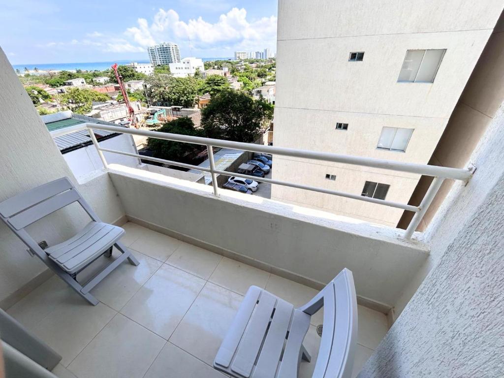 a balcony with two chairs and a view of a city at Team Renacer Broker Brisas del Mar and Pool in Cartagena de Indias