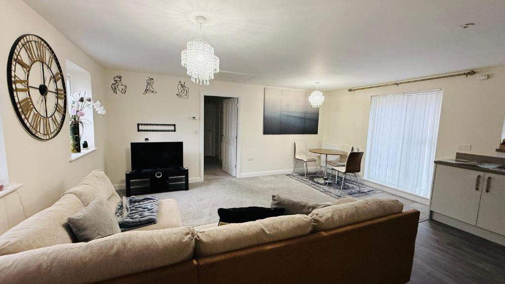 Una sala de estar con un sofá y un televisor. en Two bedroom coach house in brooklands - MK, en Milton Keynes