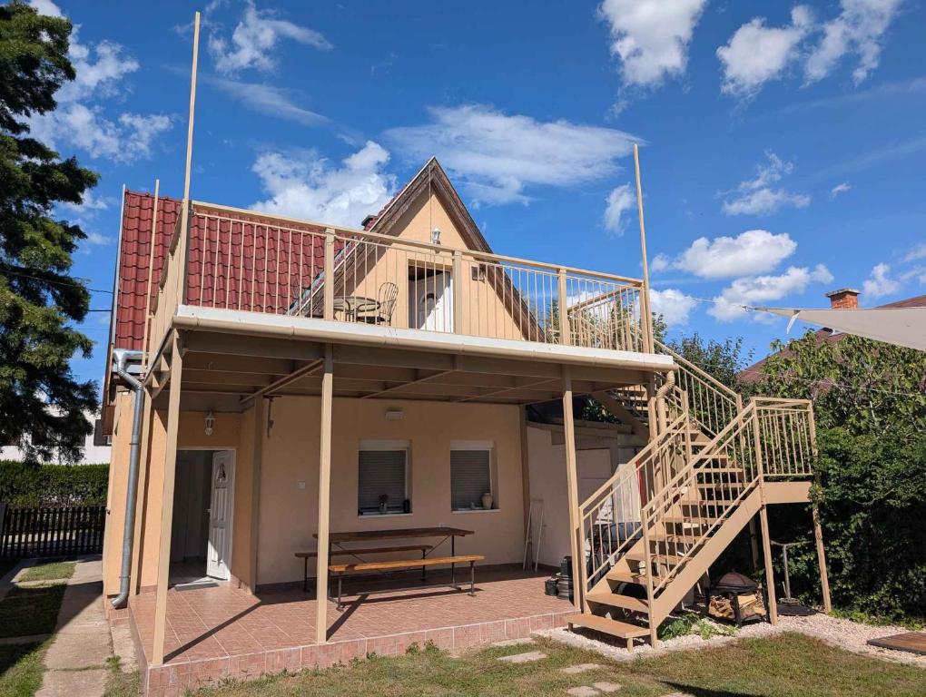 a house with a deck and a bench on a patio at Holiday home in Zamardi - Balaton 53551 in Zamárdi