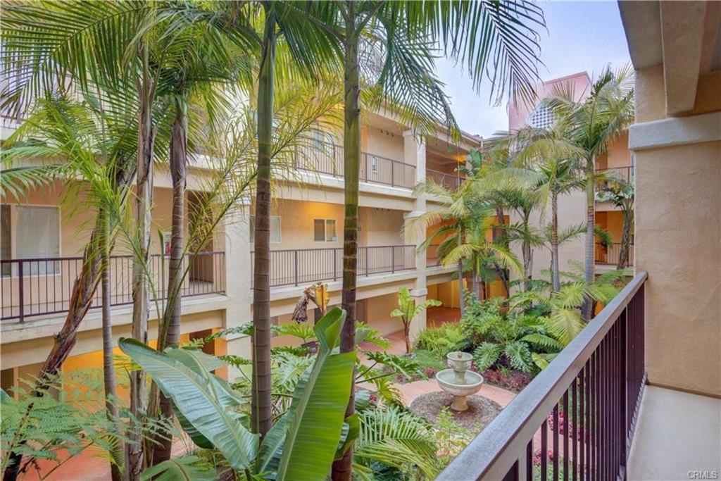 an apartment building with palm trees and a balcony at Downtown Pismo Beach modern updated single-level in Pismo Beach
