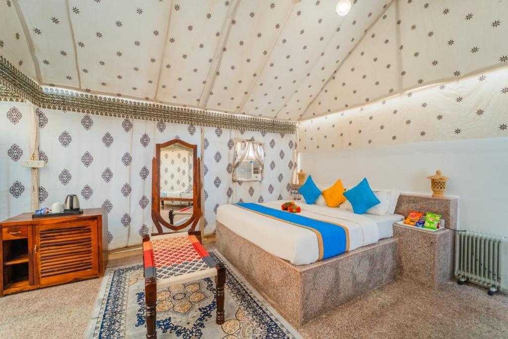 een slaapkamer met een bed, een tafel en een spiegel bij Desert Heritage Jaisalmer Camps & Resort in Jaisalmer