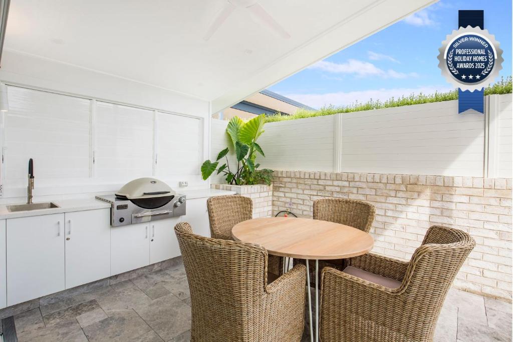 a kitchen with a wooden table and chairs at Unwind Pet Friendly 1 Min Walk to Beach in Culburra Beach