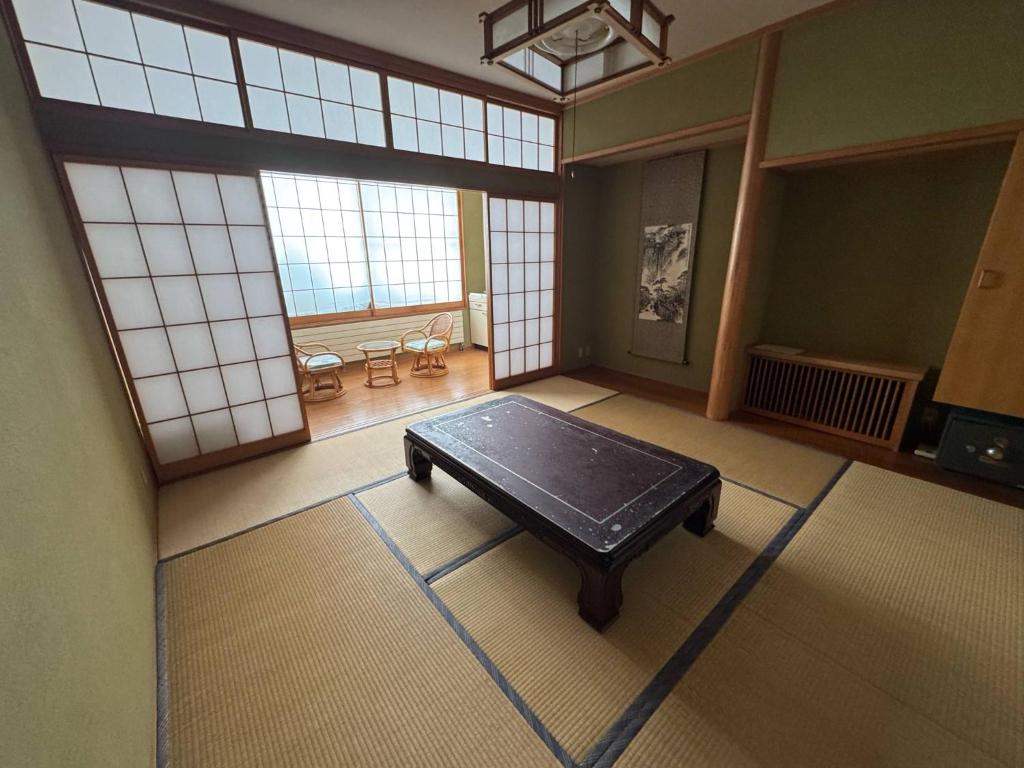 an empty room with a table in a room with windows at Hygge KAWATABI in Osaki