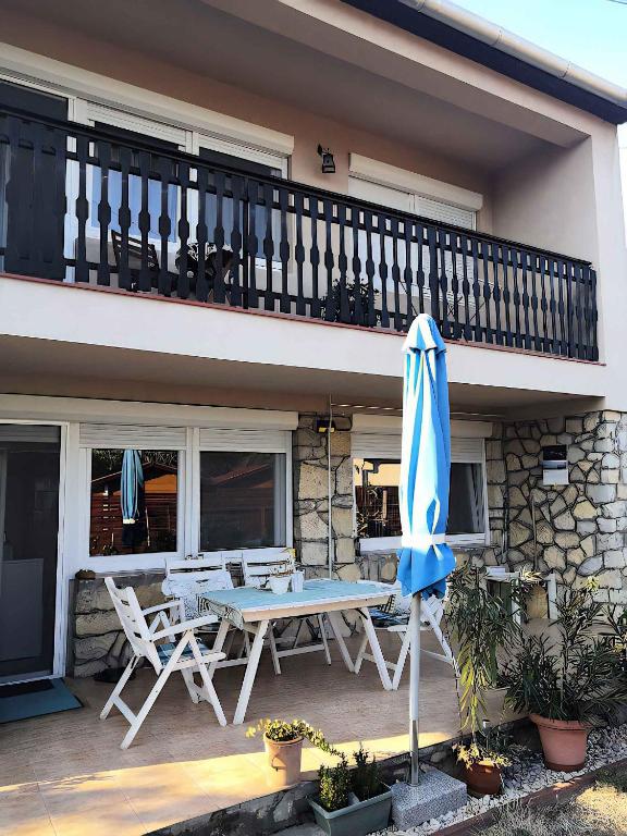 a patio with a table and chairs and an umbrella at Studio in Csopak - Balaton 48108 in Csopak