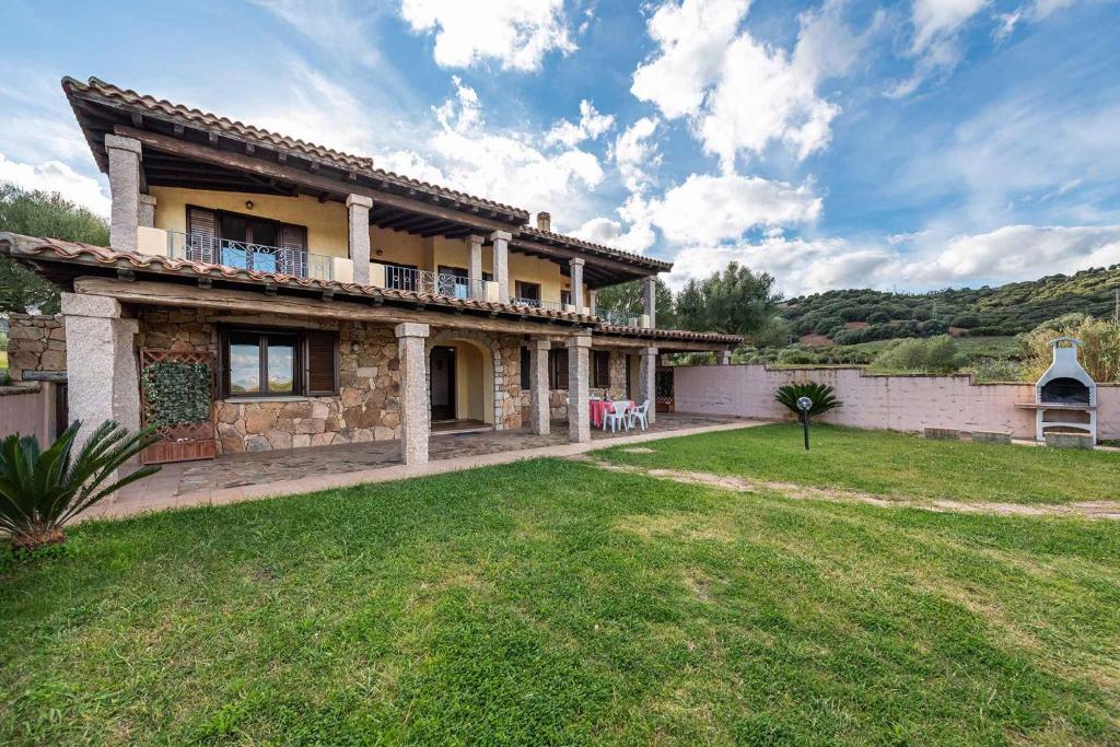 una gran casa de piedra con un patio delante en House and Apts. Siniscola - Sardinien 35758, en Santa Lucia