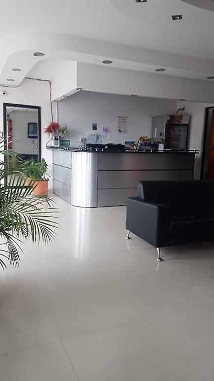 a living room with a black couch and a counter at Hotel Galerias in Ruiosucio