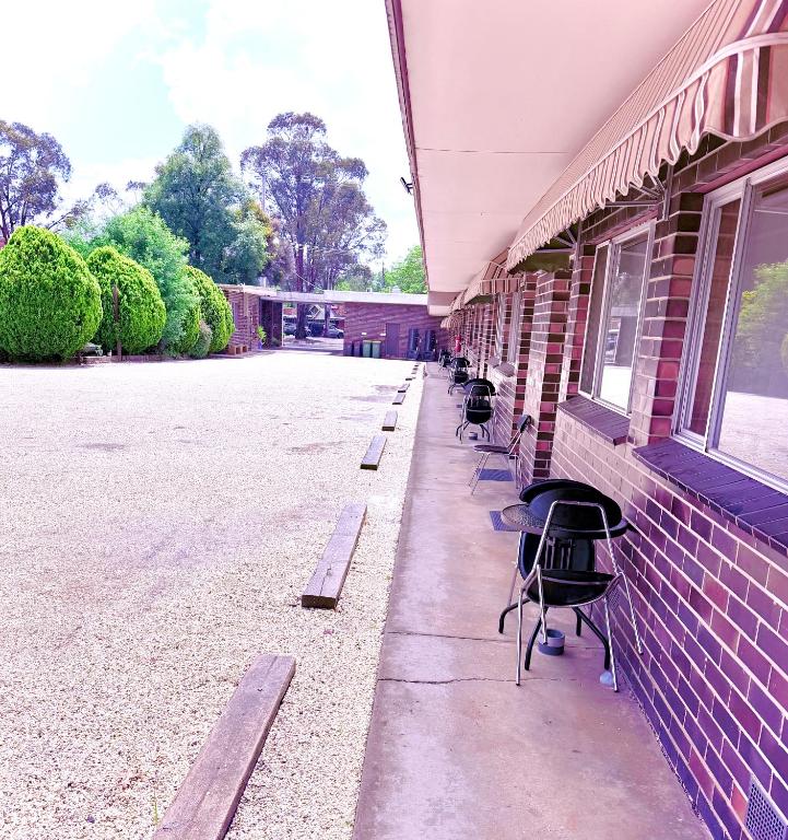 a row of chairs sitting outside of a building at Tartan Motel, Yea in Yea