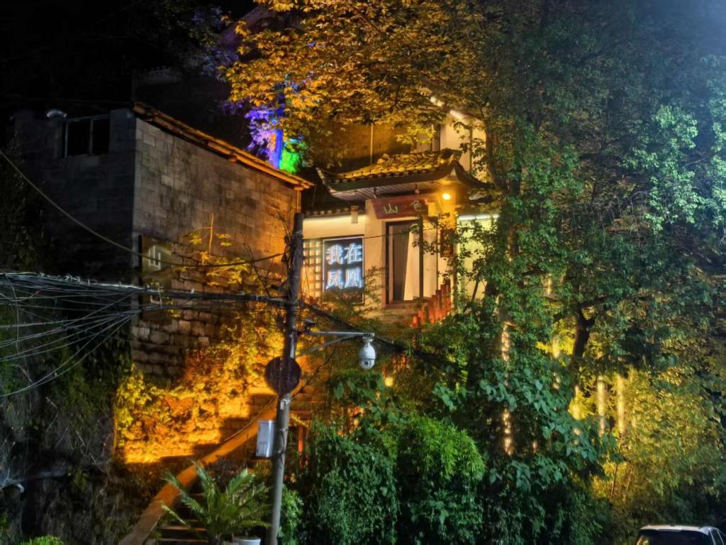 een huis met lichten aan de zijkant 's nachts bij Phoenix Mountain View Courtyard Homestay in Fenghuang