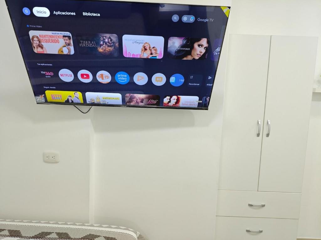 a flat screen tv hanging on a wall at Habitacion con entrada independiente y aire acondicionado, Centro Piura in Piura