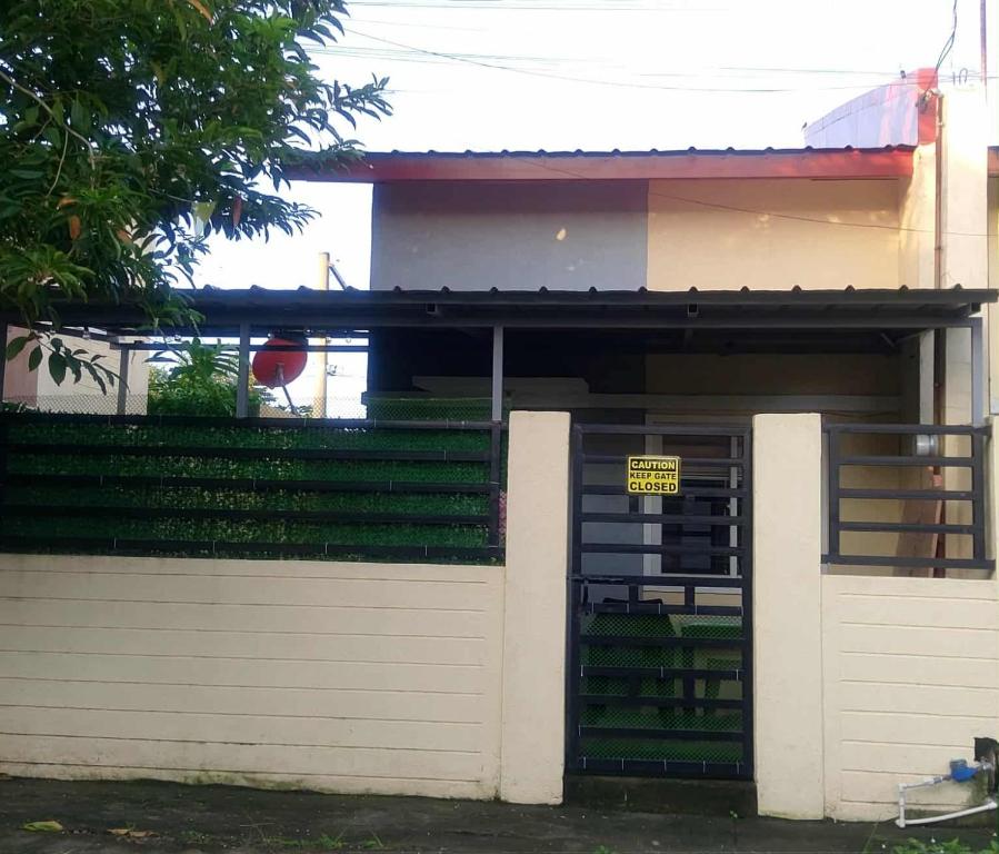 Ein Haus mit Garage und einem Schild an der Tür in der Unterkunft Gee Staycation in Santo Tomas