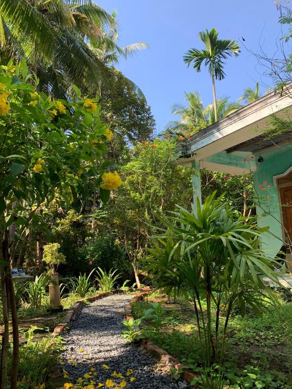 a garden with a gravel path next to a house at Bến Tre Homestay in Ben Tre