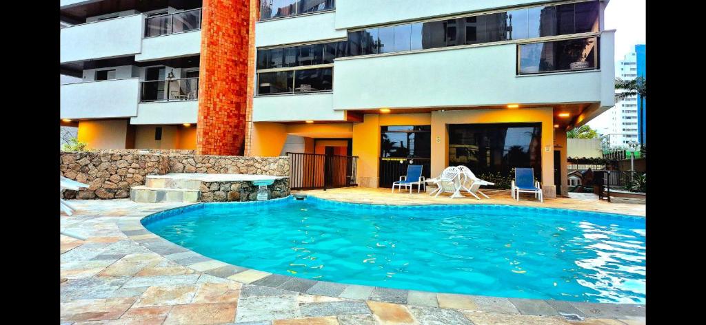 a swimming pool in front of a building at Varandas do Atlântico in Guarujá